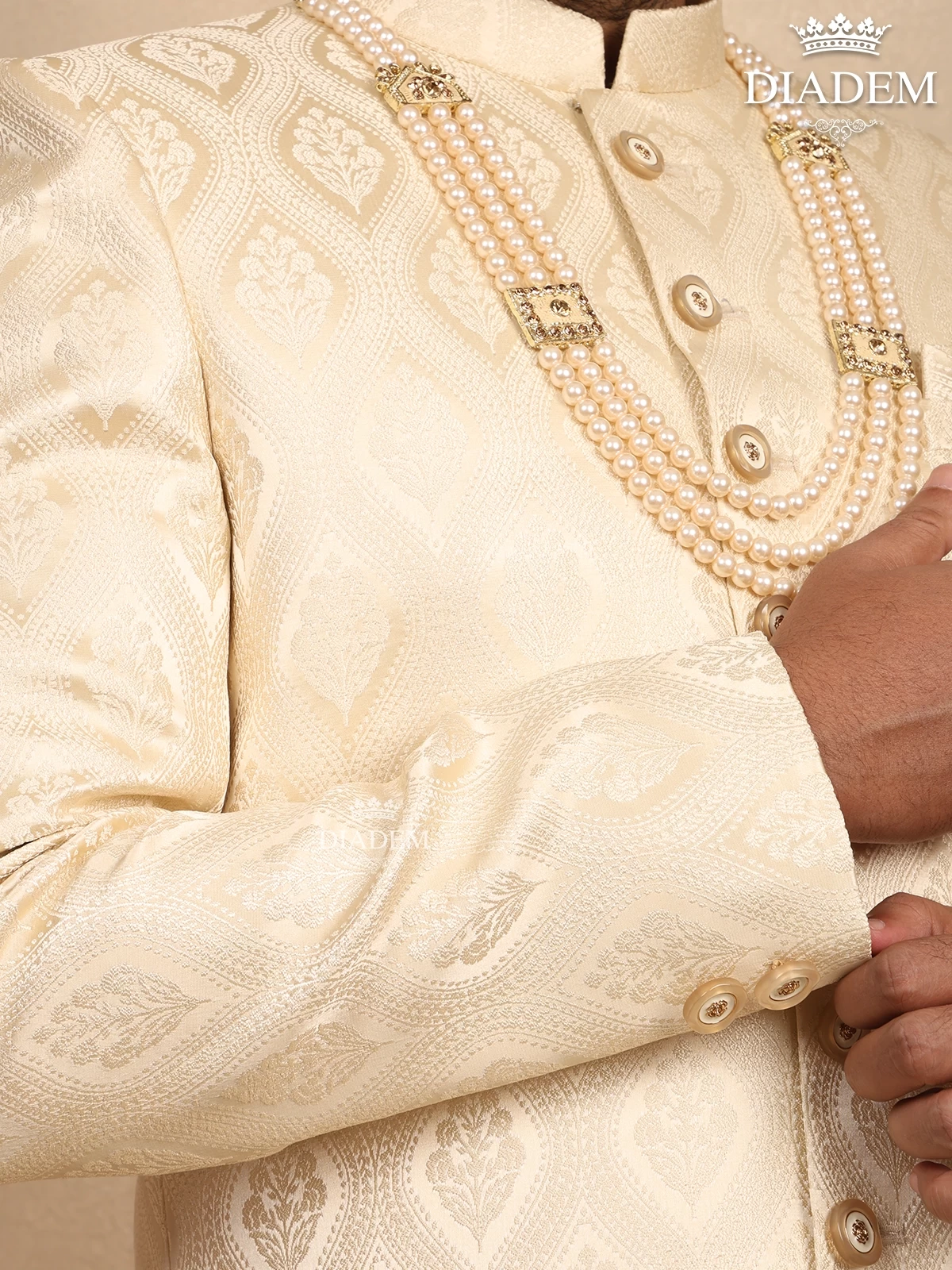 Cream Raw Silk Sherwani Suit Adorned With Floral Embroidery, Paired With Brooch And Bead Mala